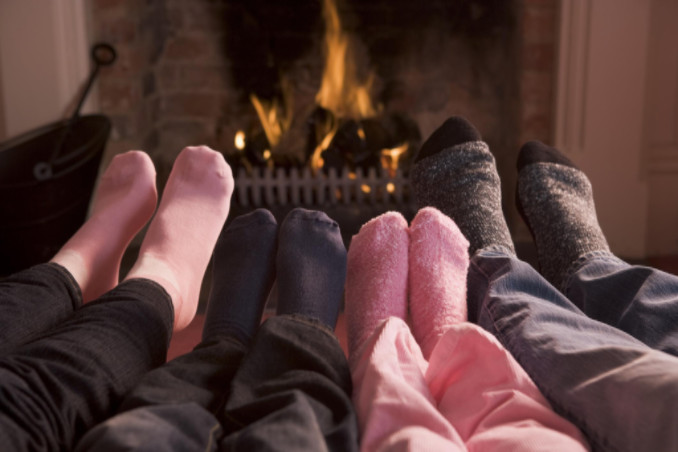 Family of four warming feet by fireplace: Gagne Maintenance Blog