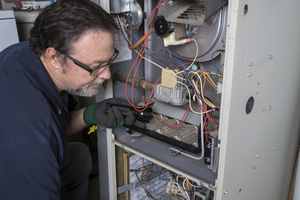 One of our technicians performing an emergency heating service for a client