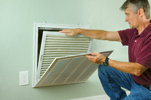 Man changing HVAC filter in his home.