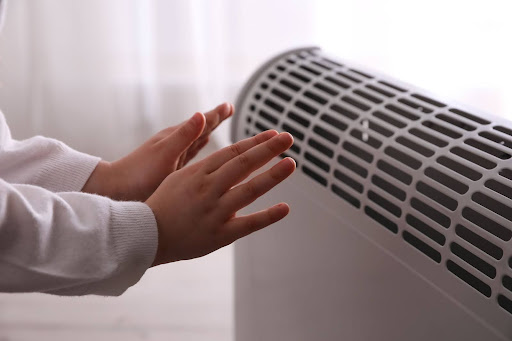 Hands hovering over radiator