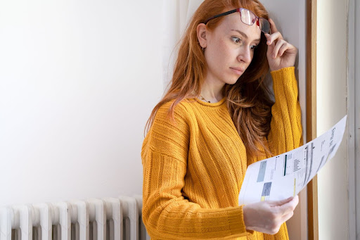 Woman looking at heating bill in surprise